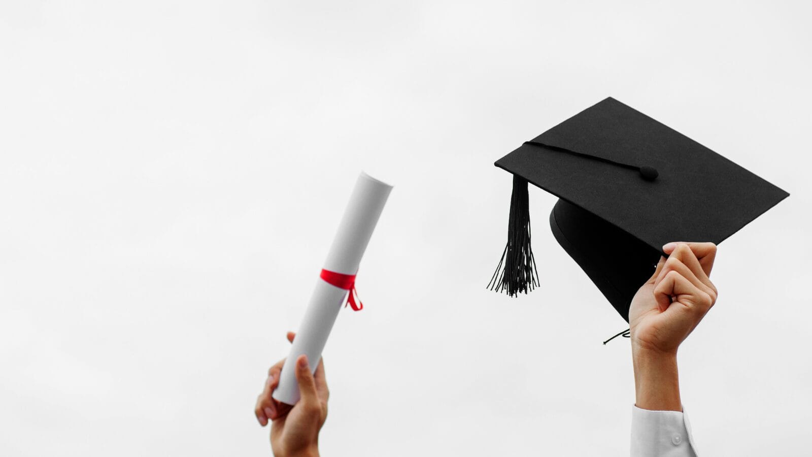 Hands holding a cap and mortarboard and a diploma